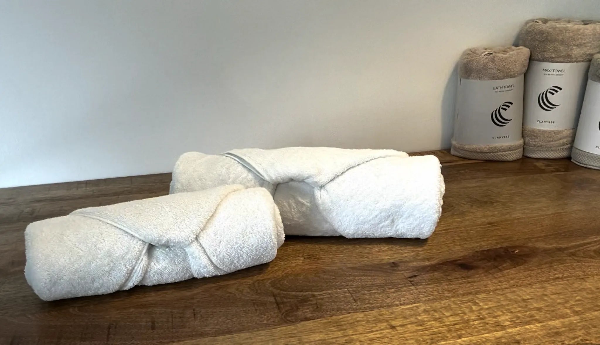 Luxe handdoeken gevouwen in boutique hotelstijl op een houten oppervlak.